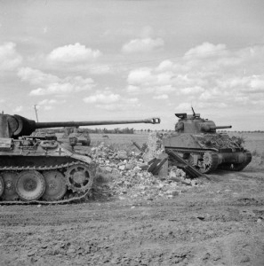 A Sherman tank of 24th Lancers, 8th Armoured Brigade, passing a knocked-out German PzKpfw V Panther tank near Rauray, 30 June 1944. © IWM (B 6226)